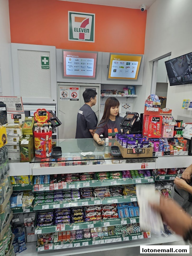 A 7-Eleven store counter with staff, snacks, and payment terminals.