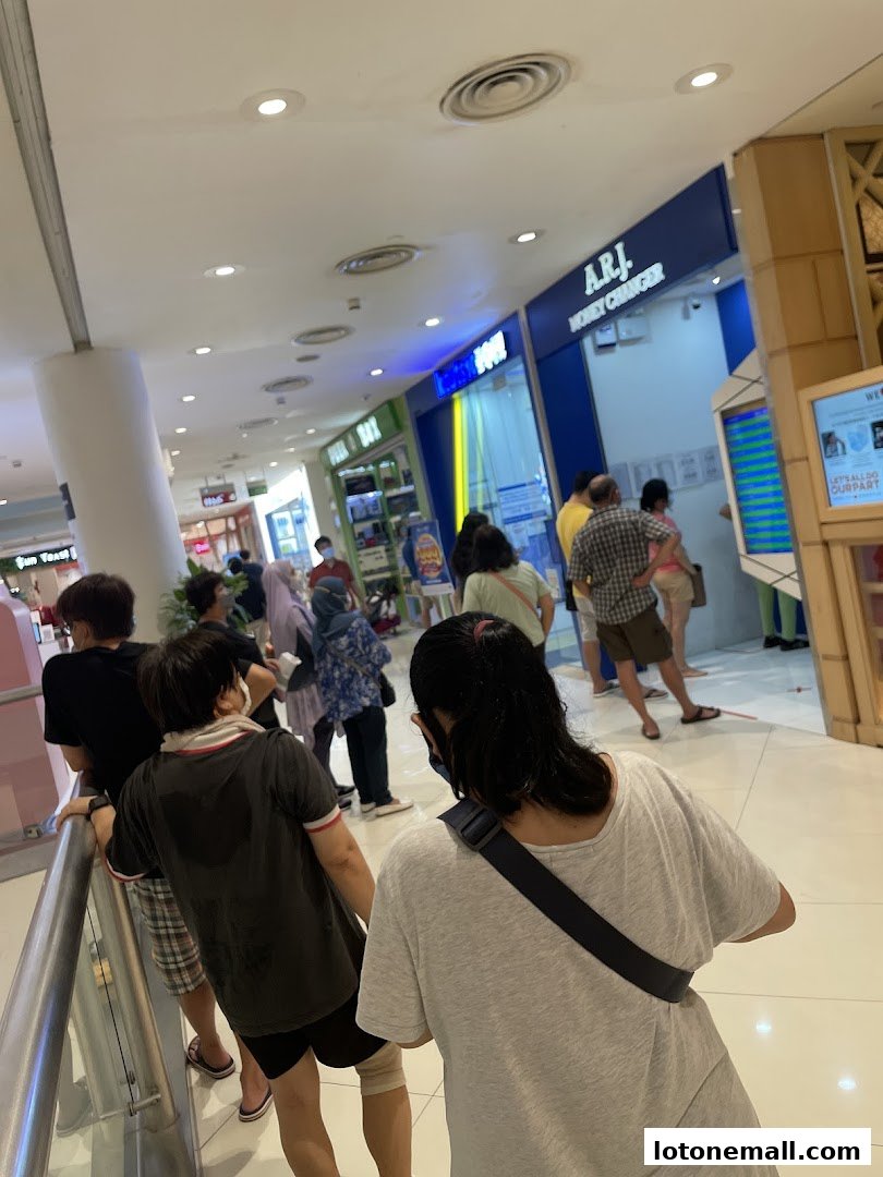 People queuing at A.R.J. Money Changer in a shopping mall.