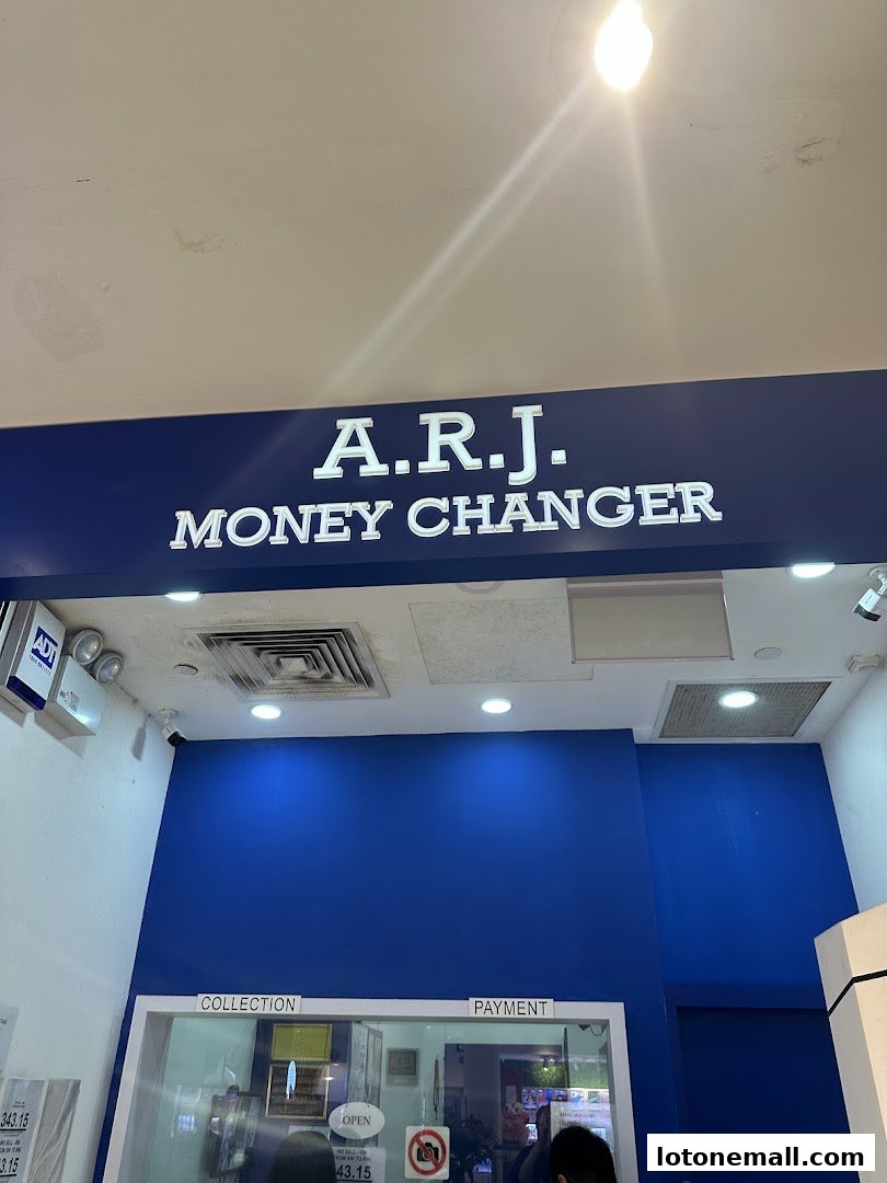 The exterior of A.R.J. Money Changer shop with its prominent signage and blue walls.