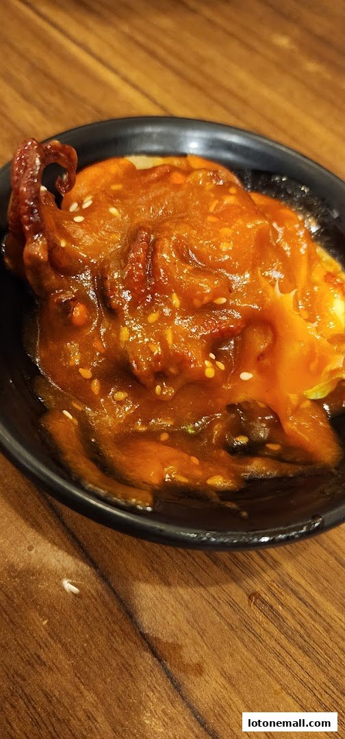 A close-up of a bowl of ramen with a rich, savory broth and toppings.