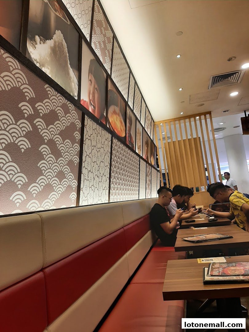 Diners seated at tables in a restaurant with decorative wall art and comfortable seating.