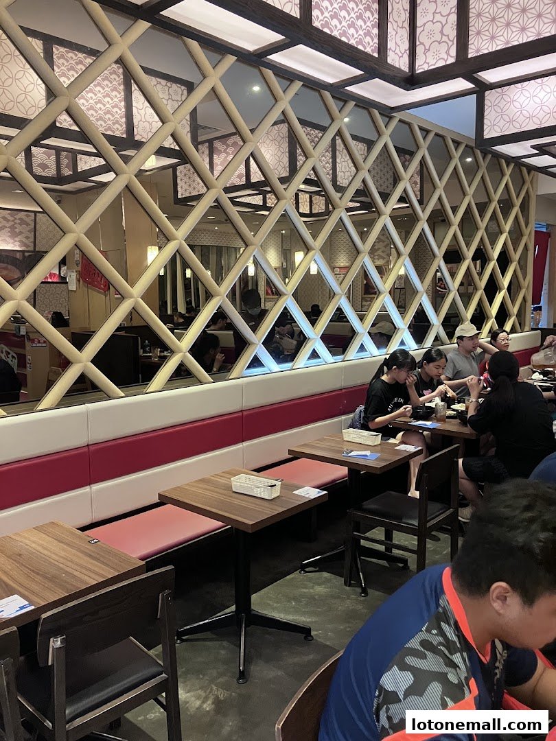 Interior shot of Ajisen Ramen restaurant with diners seated at tables.