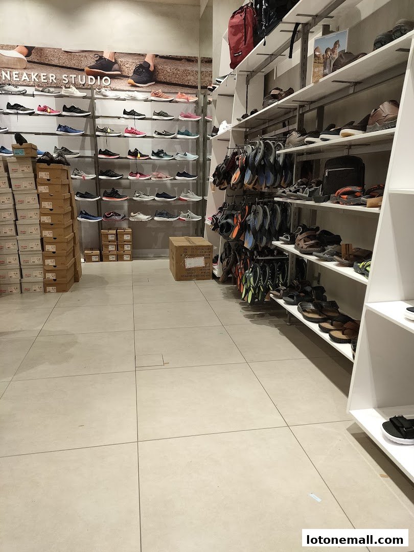 Interior view of a Bata shoe store showcasing a wide selection of sneakers and sandals on display.