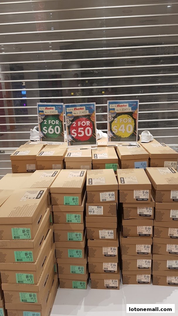 Bata shoe boxes stacked high with promotional signs for '2 for' deals.