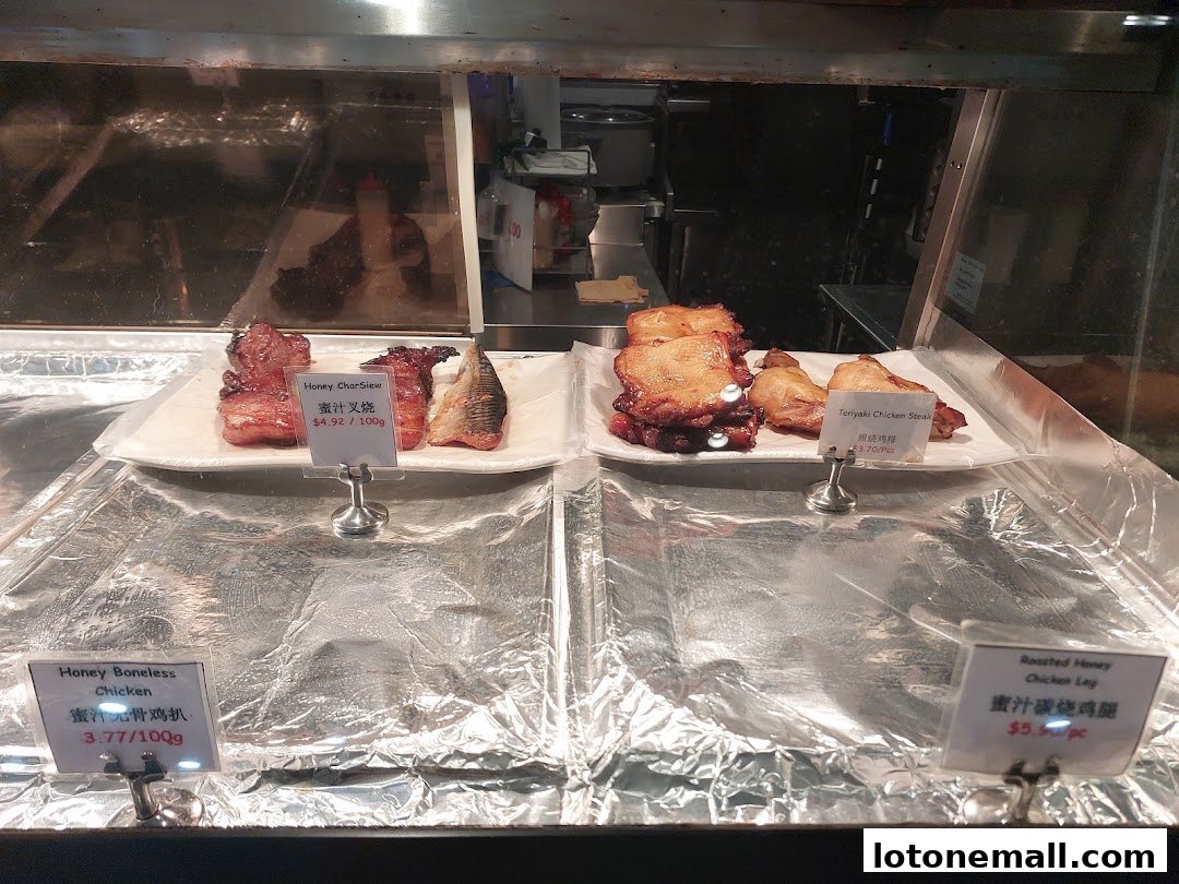 Display case with various roasted and glazed chicken dishes and char siu.