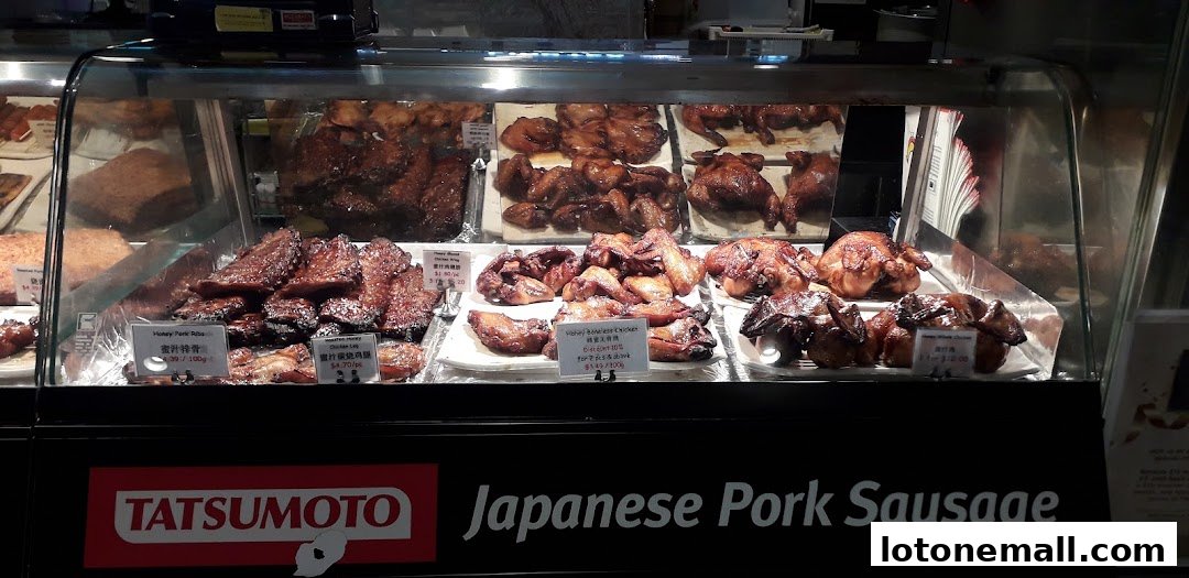 A display case filled with various roasted meats, including ribs and whole chickens.