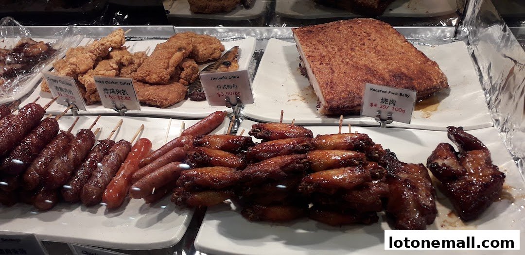 A display of various BBQ meats including sausages, chicken wings, crispy chicken, and roasted pork belly.