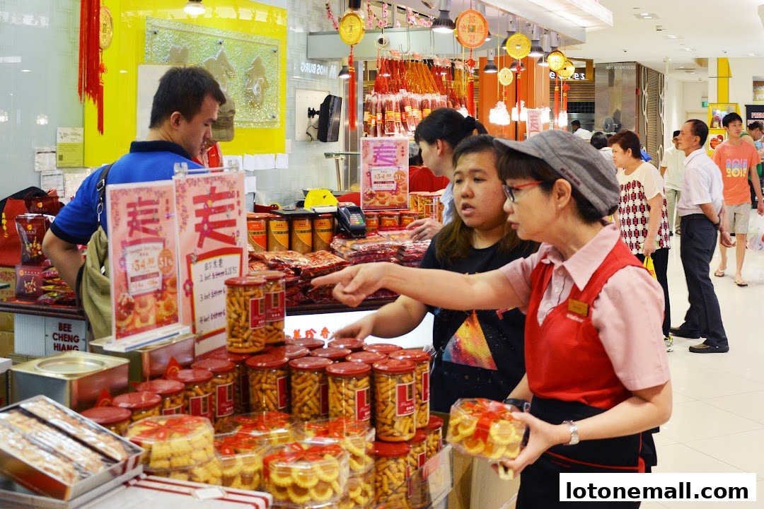 Customers and staff interact at a Bee Cheng Hiang store, showcasing various food products and promotions.
