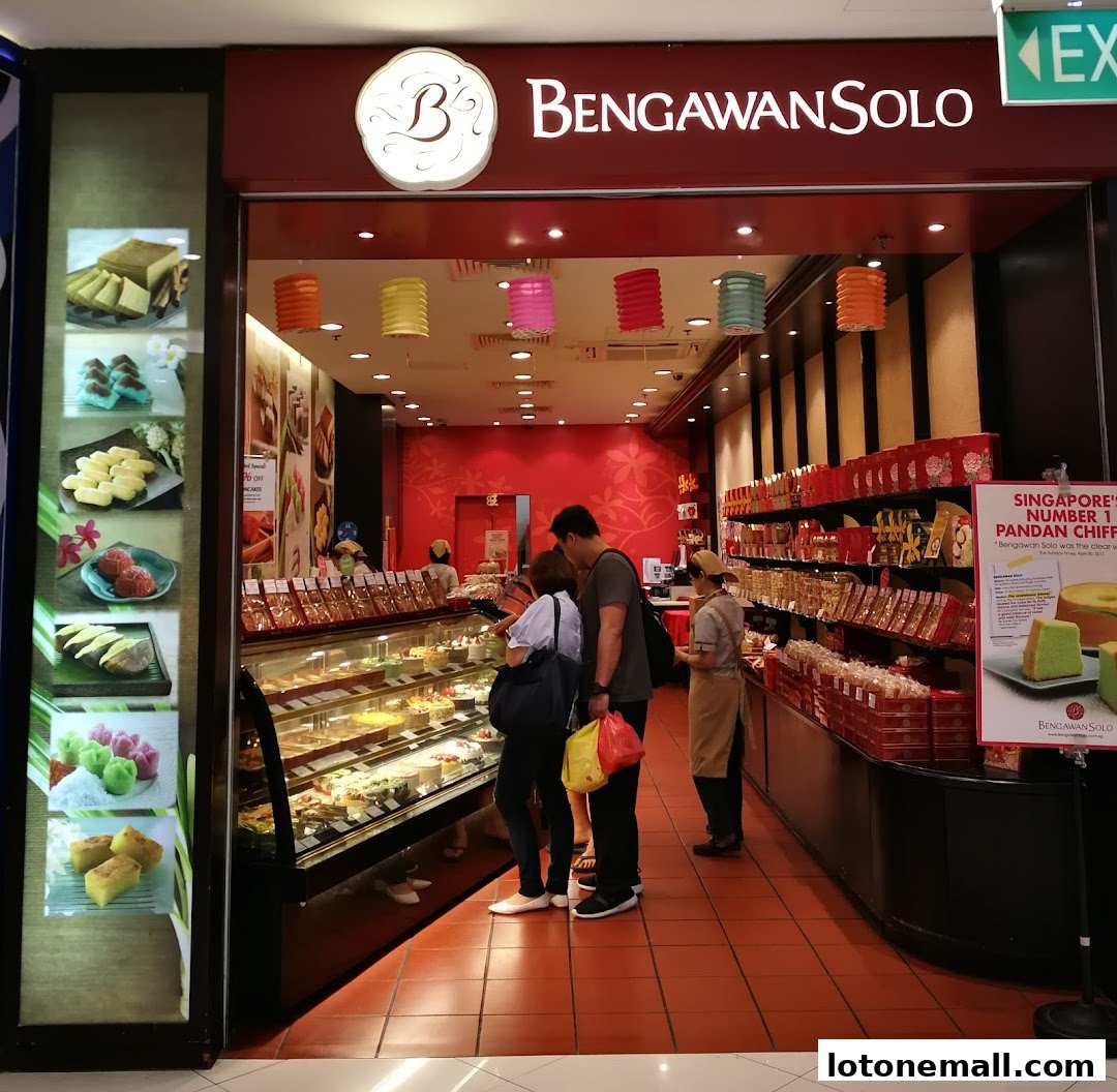 The entrance of Bengawan Solo bakery, showcasing a display of cakes and pastries with customers browsing.