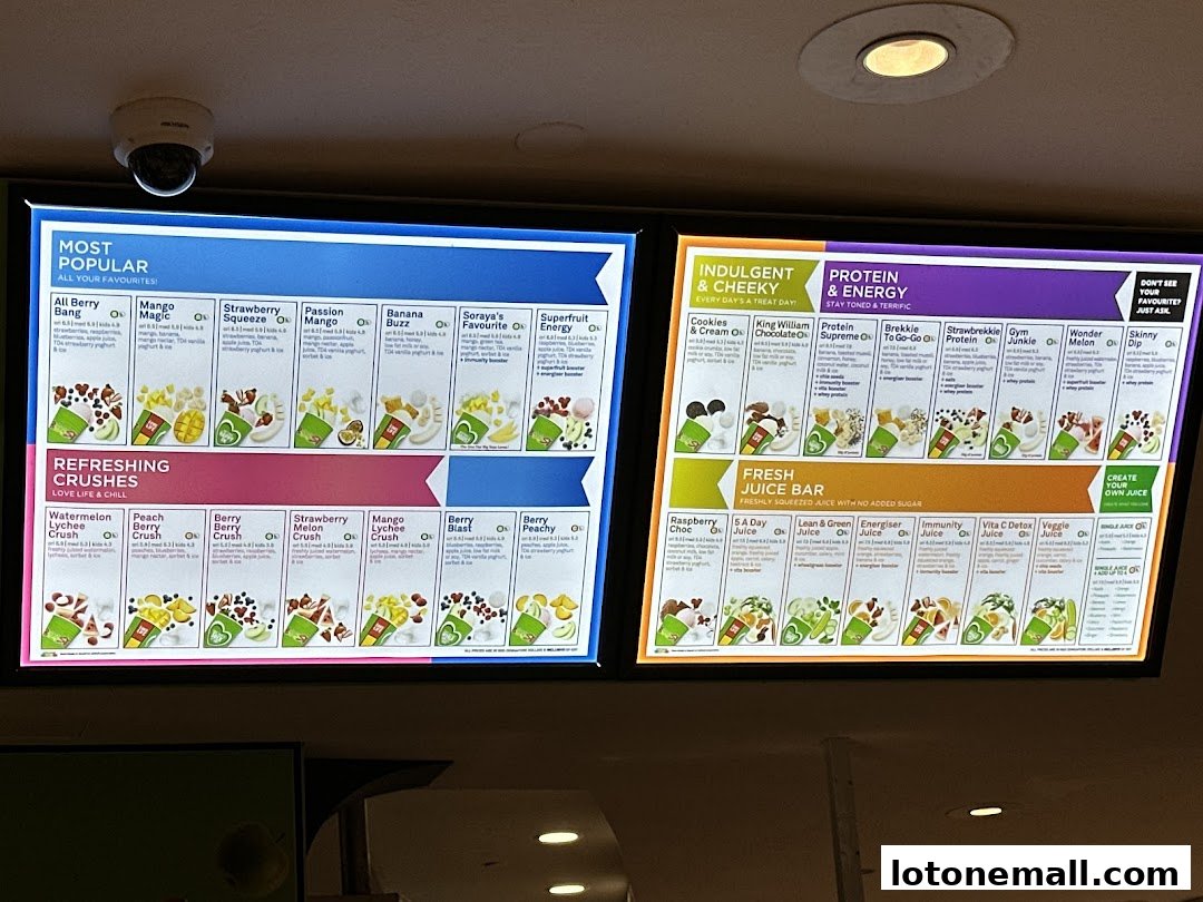 A menu board displaying various smoothies and juices with colorful images and descriptions.