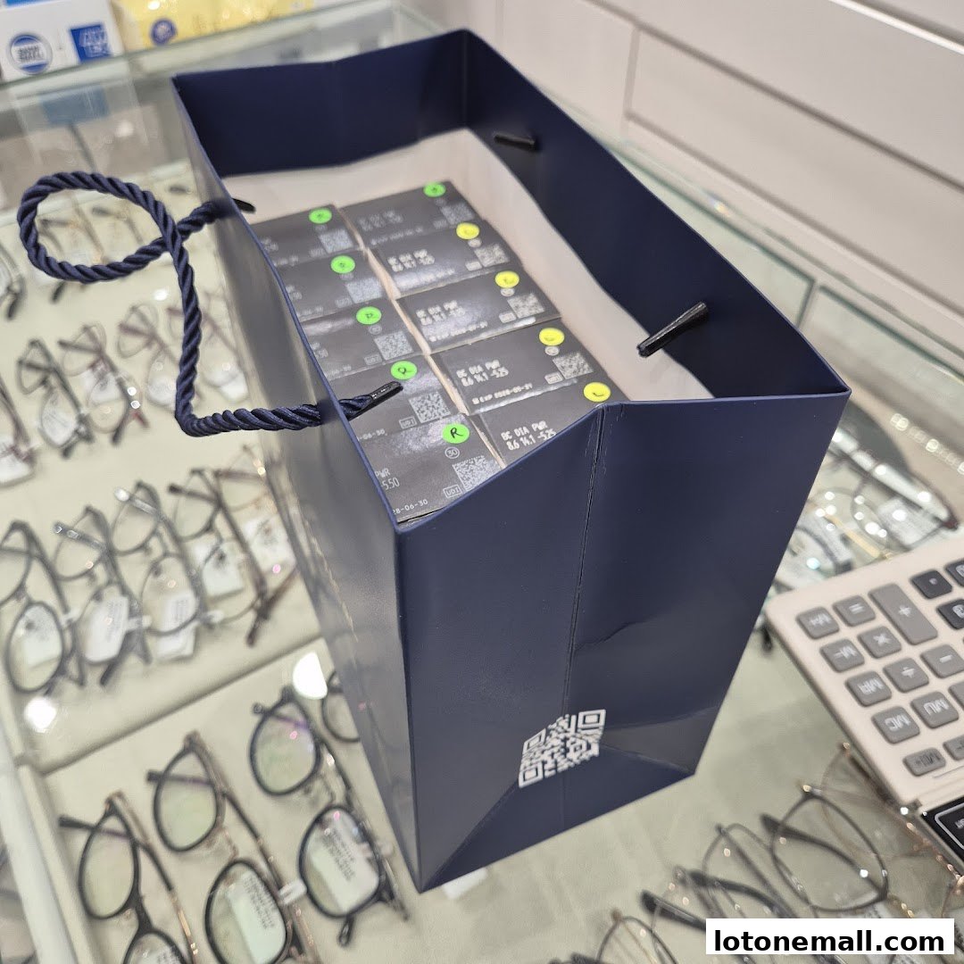 A shopping bag filled with contact lens boxes on display at an optical shop.