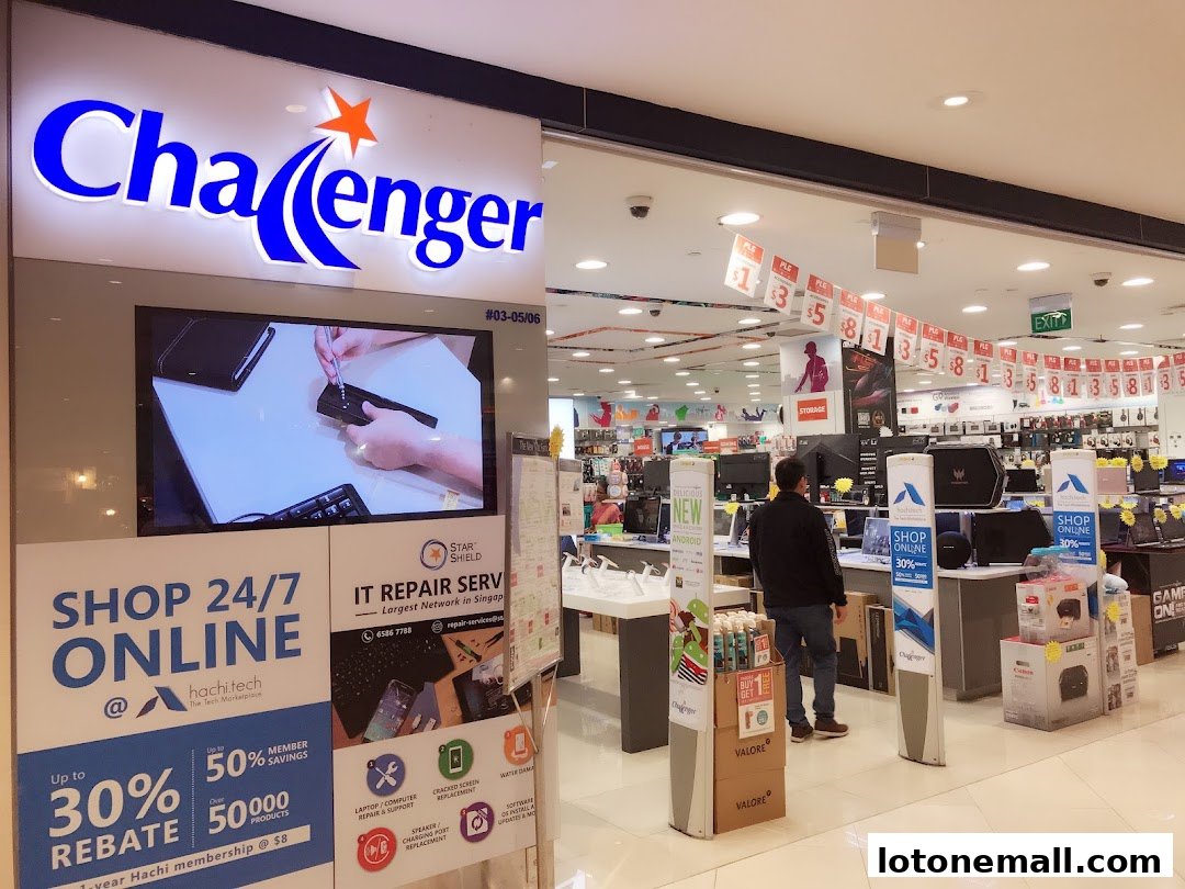 The exterior of a Challenger electronics store with a large illuminated sign and promotional displays.