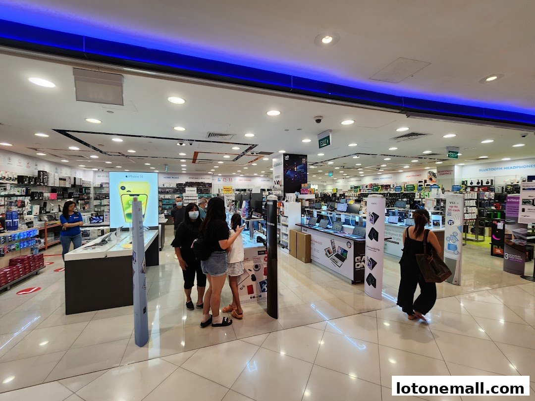 Interior view of a brightly lit electronics store with various gadgets and displays.
