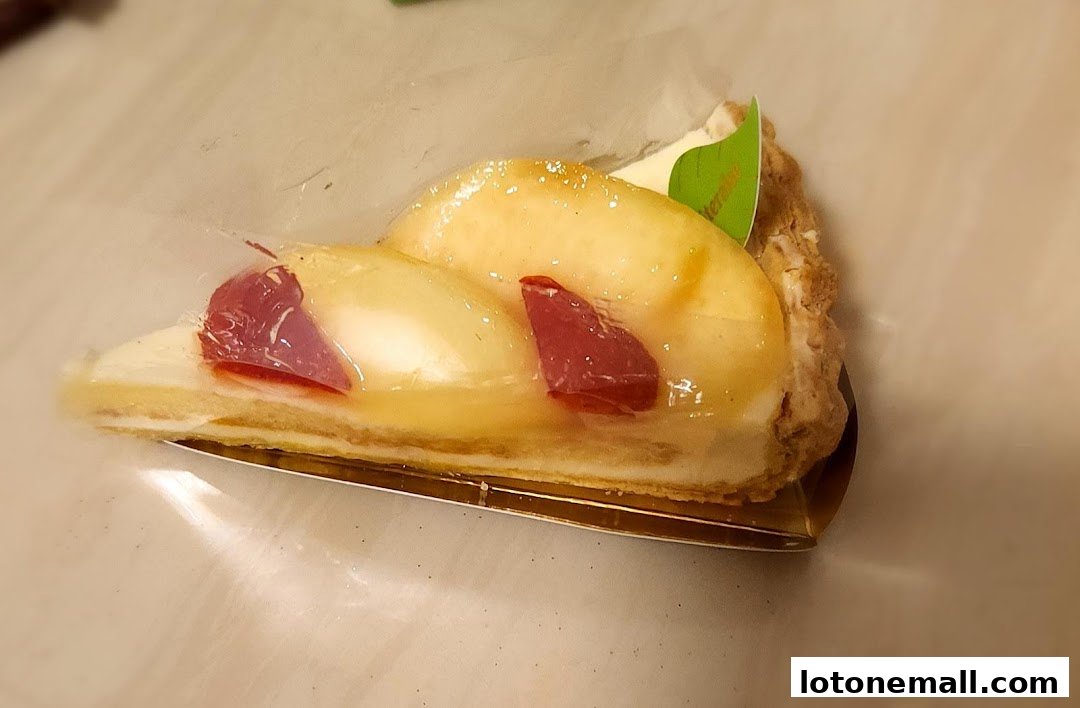 A slice of delicious fruit tart with a flaky crust and glazed fruit topping.