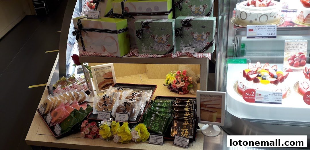 A display of various Japanese cakes and pastries, including whole cakes and individually wrapped treats.