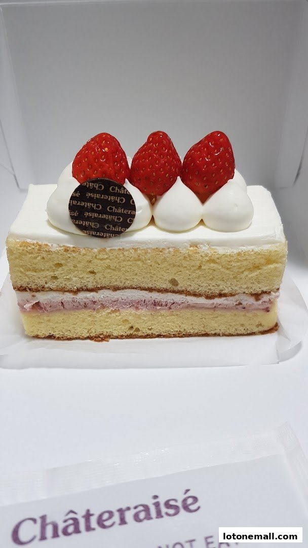 A slice of strawberry shortcake with whipped cream and fresh strawberries on top.