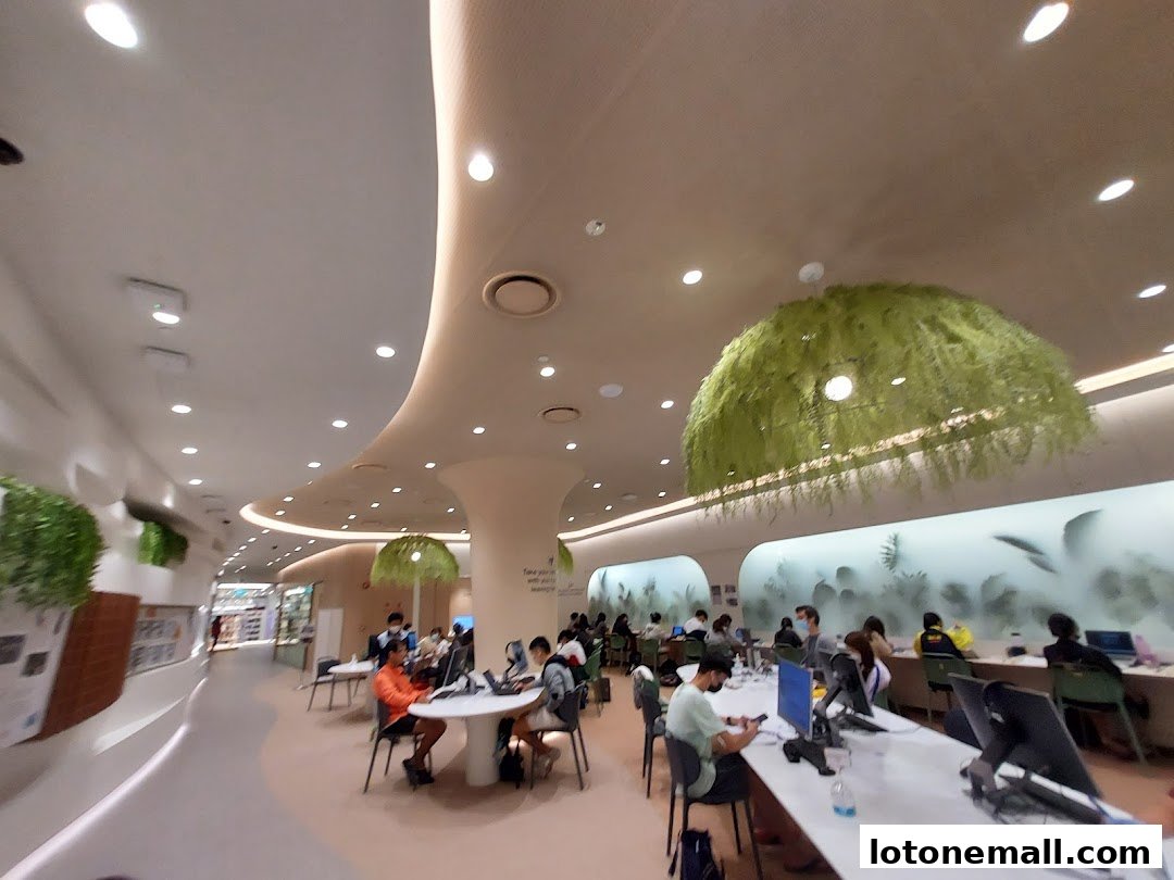 Interior view of a modern library with people studying and working at tables.