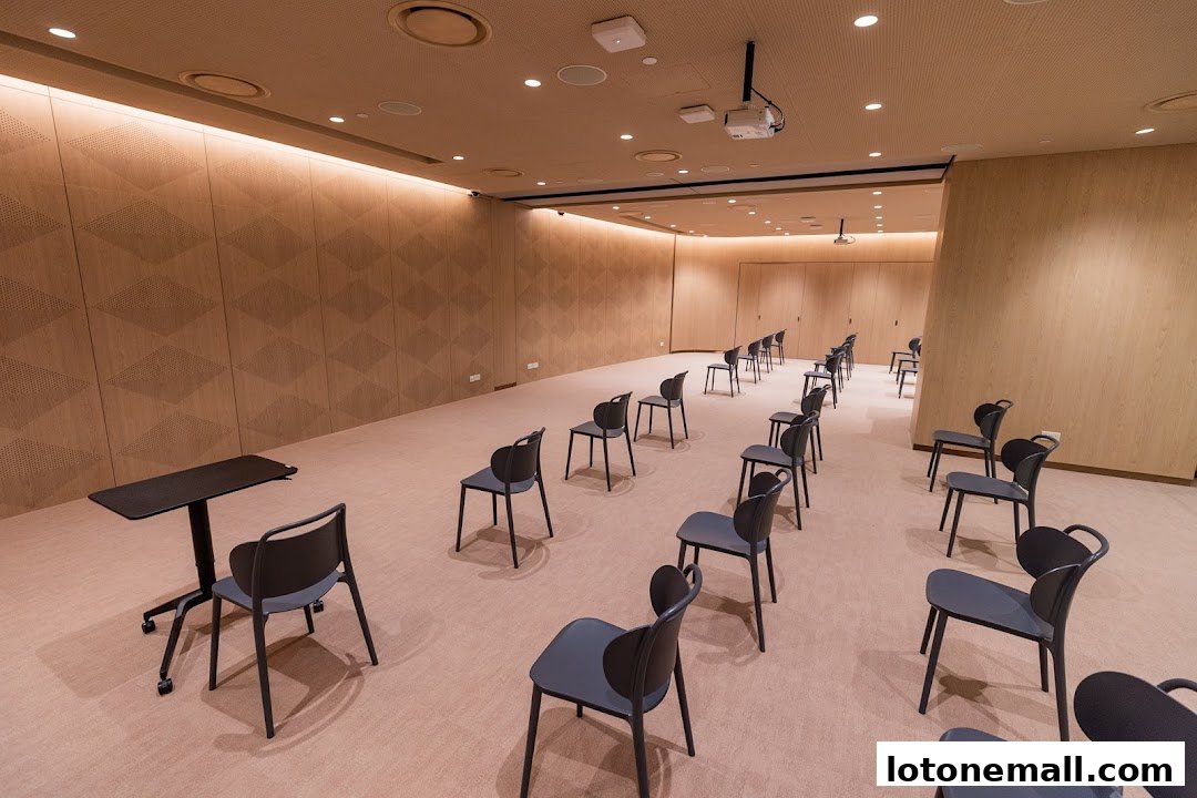 A modern meeting room with rows of chairs and a projector.