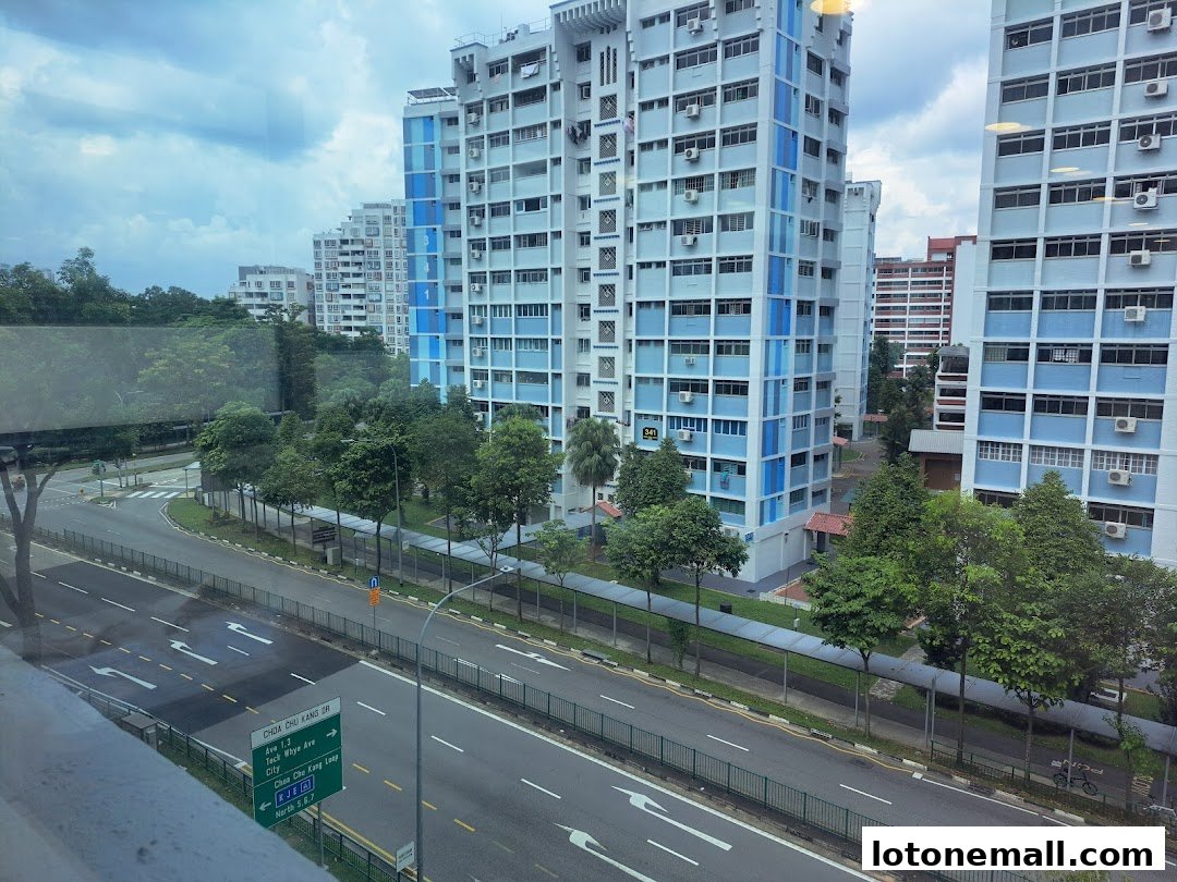 View of residential buildings and a street with a directional sign.