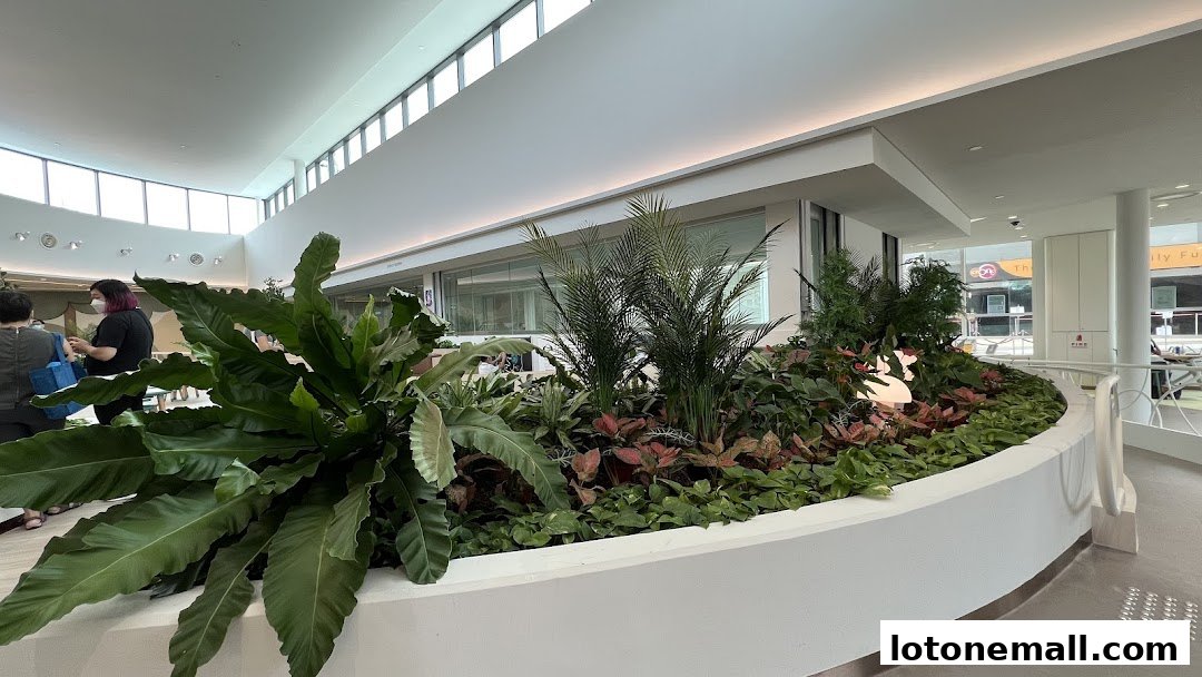Interior view of a modern building with a large planter filled with lush green plants.