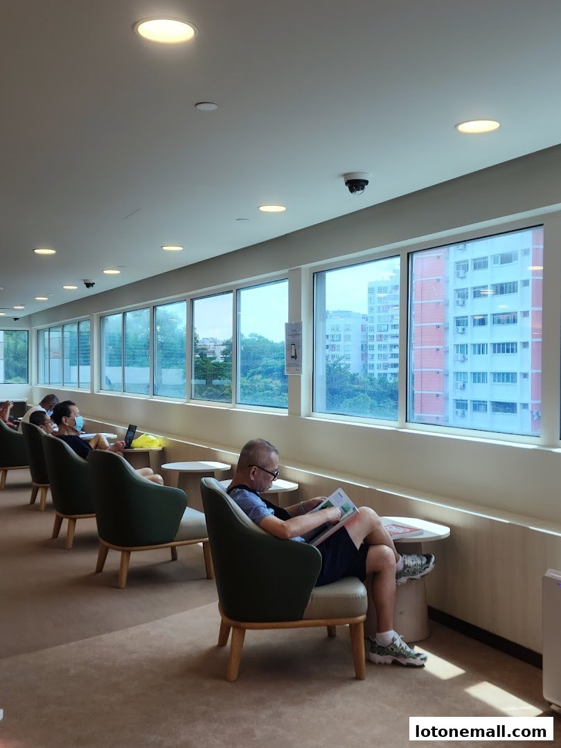 People relaxing and reading in comfortable chairs by large windows overlooking a city.