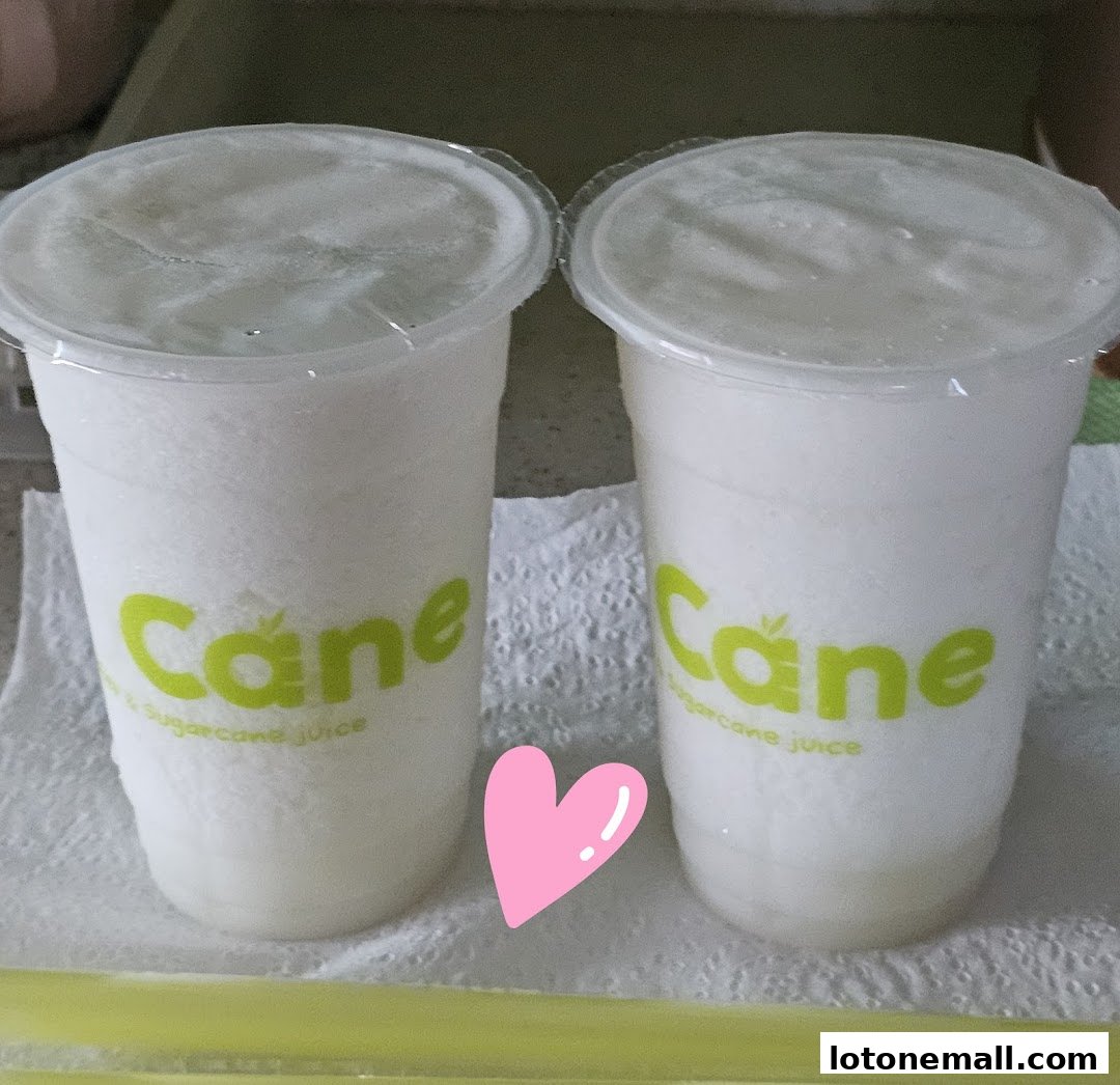Two cups of white, frothy sugarcane juice with the CocoCane logo and a pink heart.