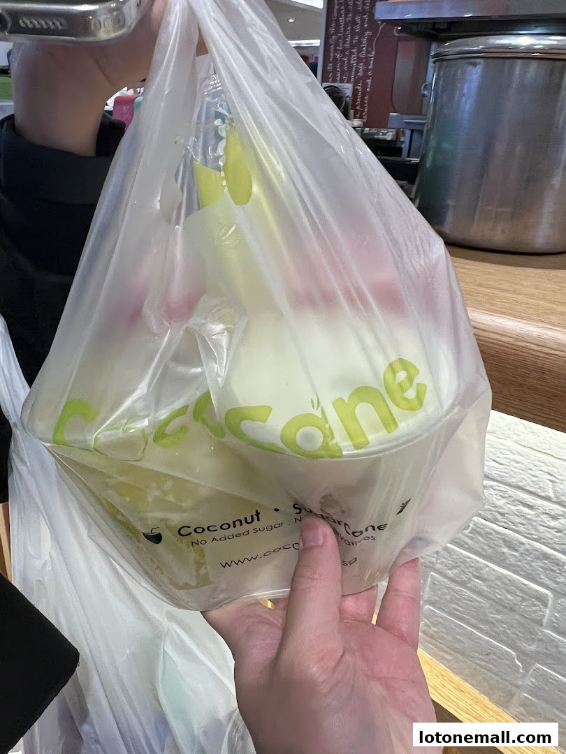 A hand holds a plastic bag filled with CocoCane products.