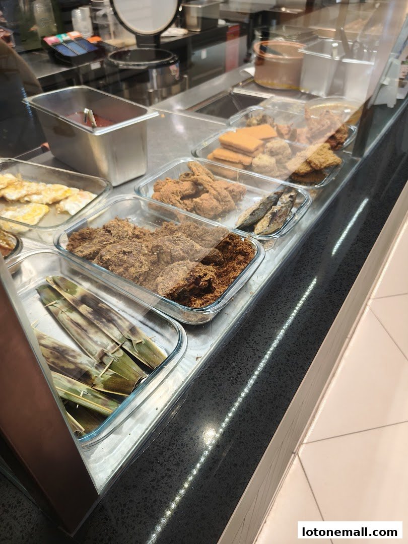 A display of various Nasi Lemak dishes and side items in glass containers.