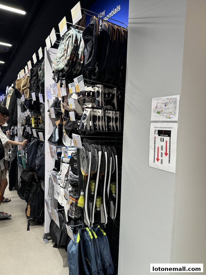 Interior shot of a Decathlon store showcasing sports equipment and accessories like backpacks and badminton rackets.