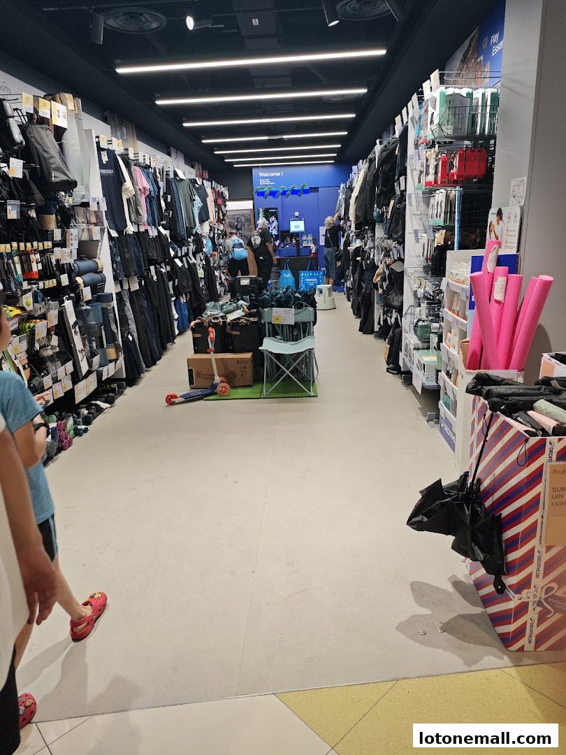 A wide aisle inside a Decathlon store, showcasing various sports apparel and equipment.