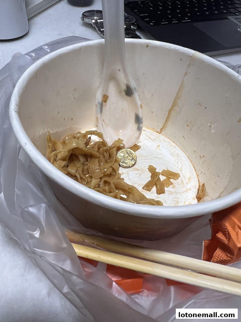 A nearly empty bowl of noodles with a spoon and chopsticks, suggesting a meal has been consumed.