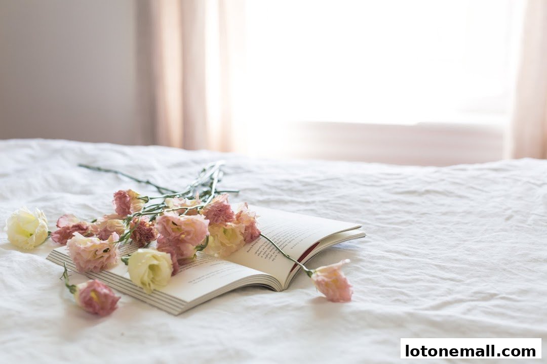 An open book with scattered pink and white flowers on a white textured surface.