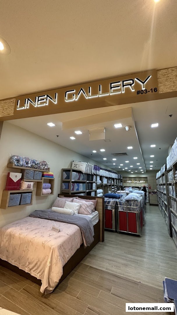Interior view of a bedding store showcasing a display bed and shelves stocked with linens.
