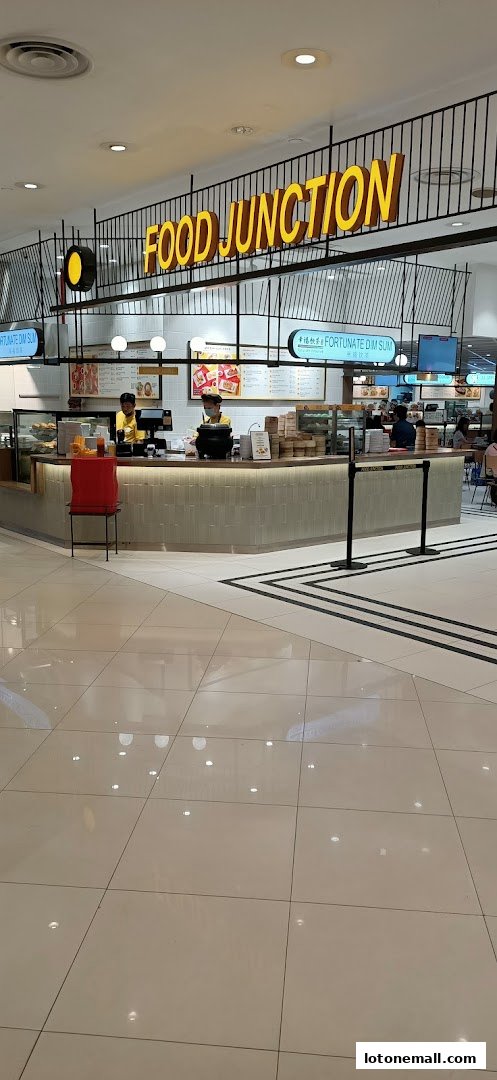A food stall counter with staff serving customers and a prominent 'Food Junction' sign.