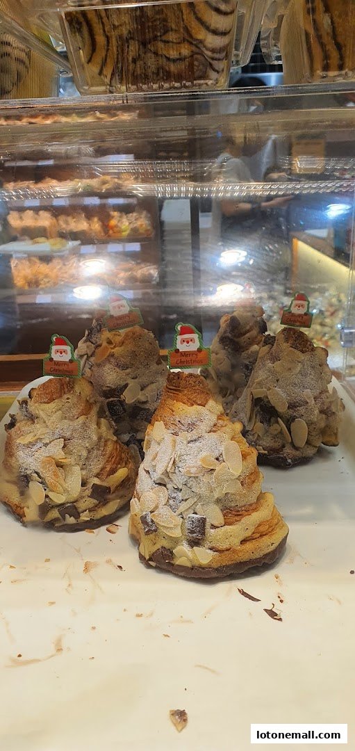 Pastries decorated with almonds and chocolate chips, topped with Christmas-themed Santa Claus decorations.