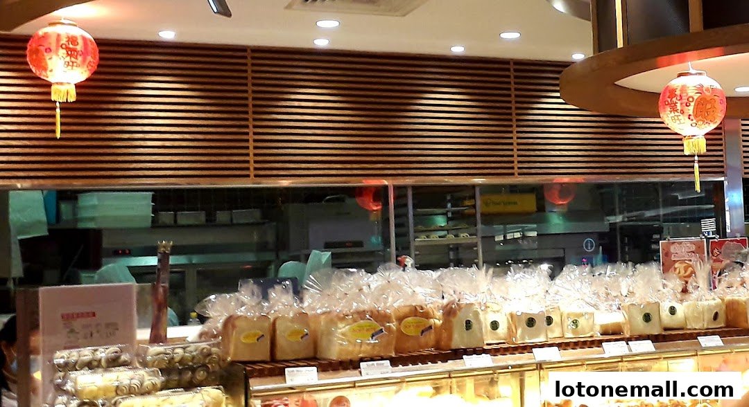 A bakery display featuring rows of bagged bread loaves and pastries, with decorative lanterns.