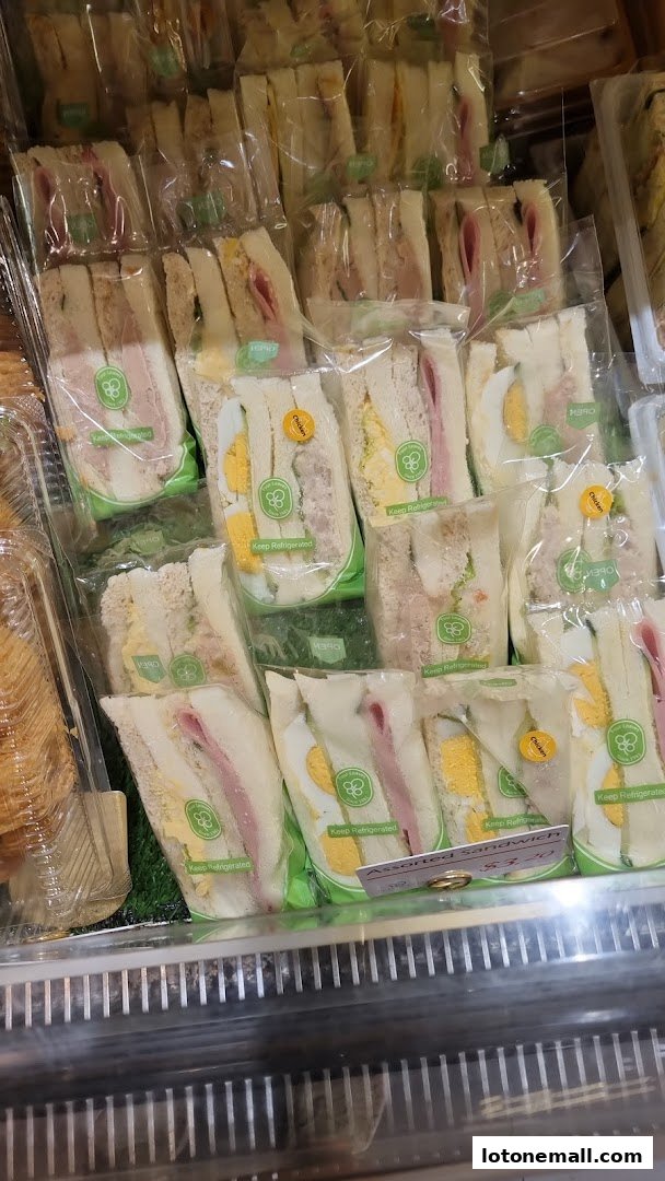 A display of individually packaged sandwiches with various fillings, ready for sale.