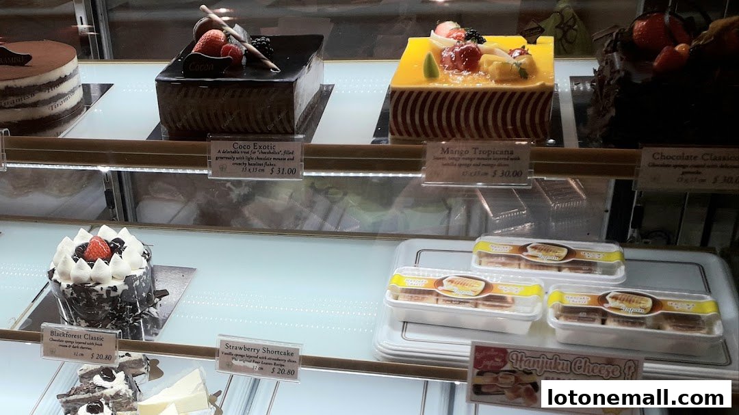 A display case filled with various beautifully decorated cakes and pastries from Four Leaves.
