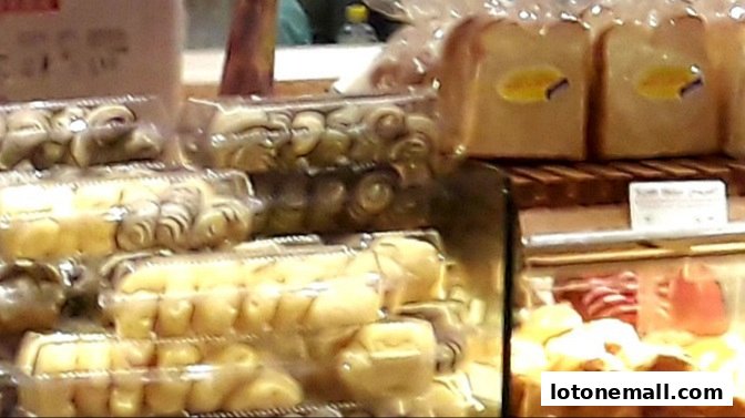 A display of freshly baked bread and pastries in clear packaging at a bakery.
