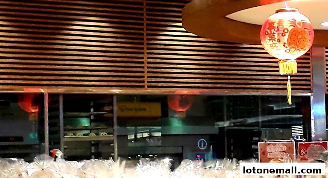 Interior view of a bakery with baked goods displayed and a decorative lantern.