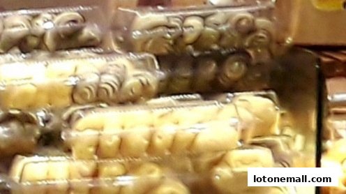 Close-up of packaged pastries and baked goods stacked in clear plastic containers.