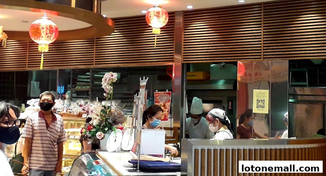 People are seen inside a bakery with decorative lanterns and displays of baked goods.