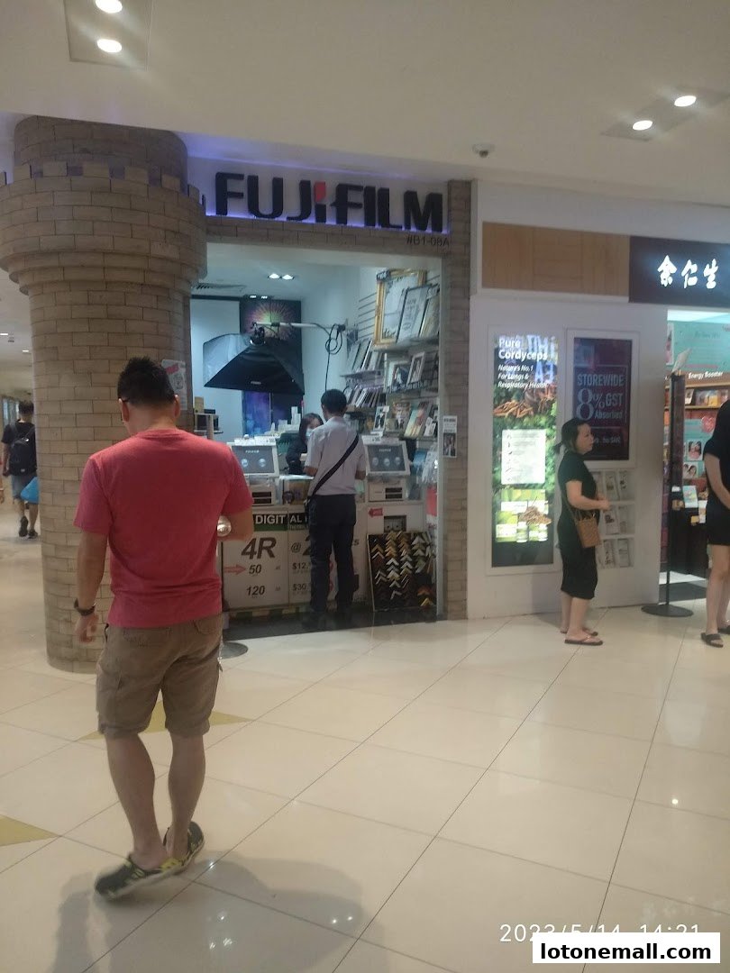 The Fujifilm Mach Photo shop entrance with a sign and displays inside.