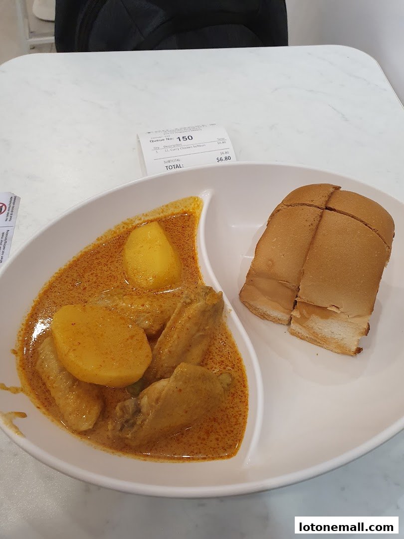 A plate of curry chicken with soft bun and a receipt from Fun Toast.