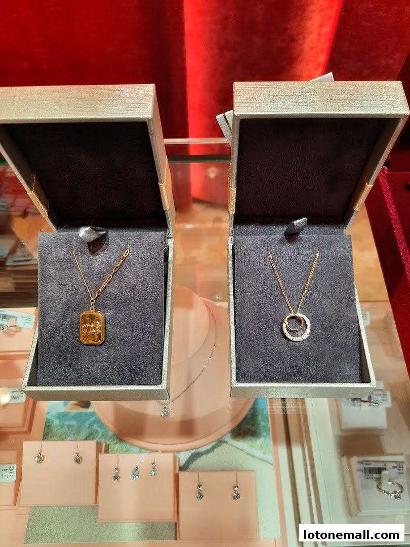 Two elegant necklaces displayed in open jewelry boxes, with earrings and rings visible below.