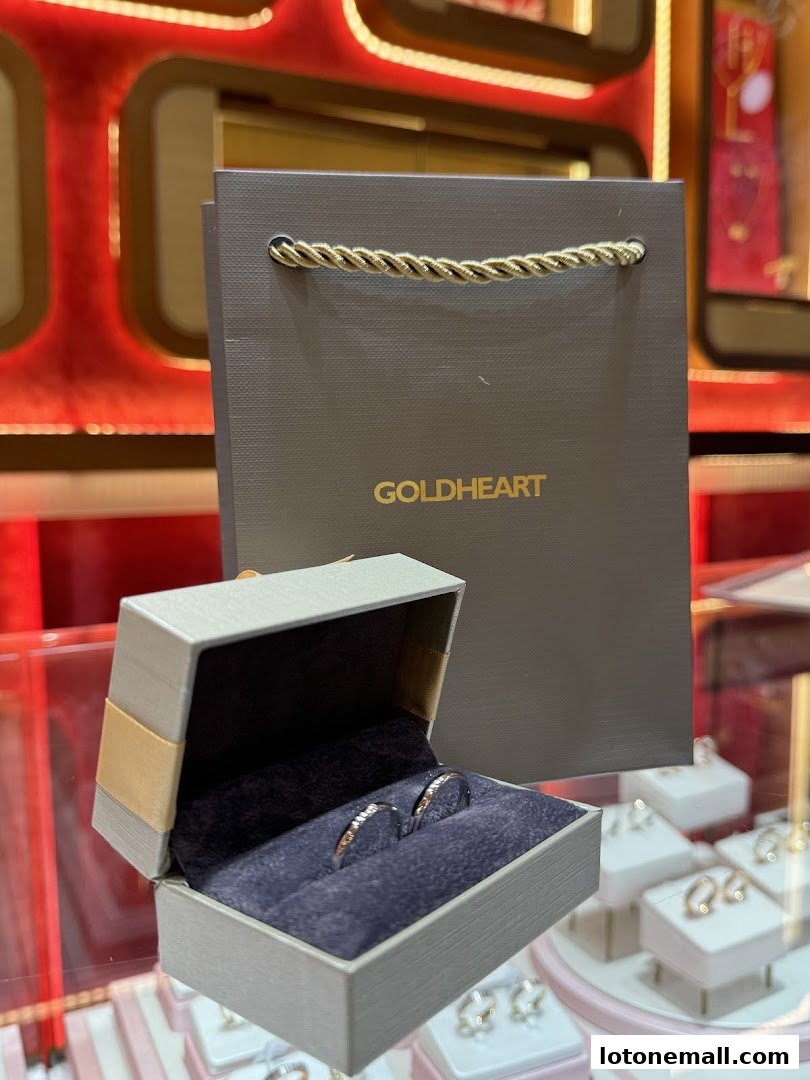 A jewelry box with two rings and a Goldheart shopping bag.