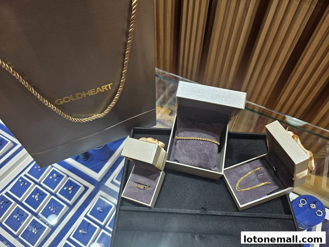 Goldheart Jewelry display featuring a shopping bag and various gold jewelry pieces in boxes.