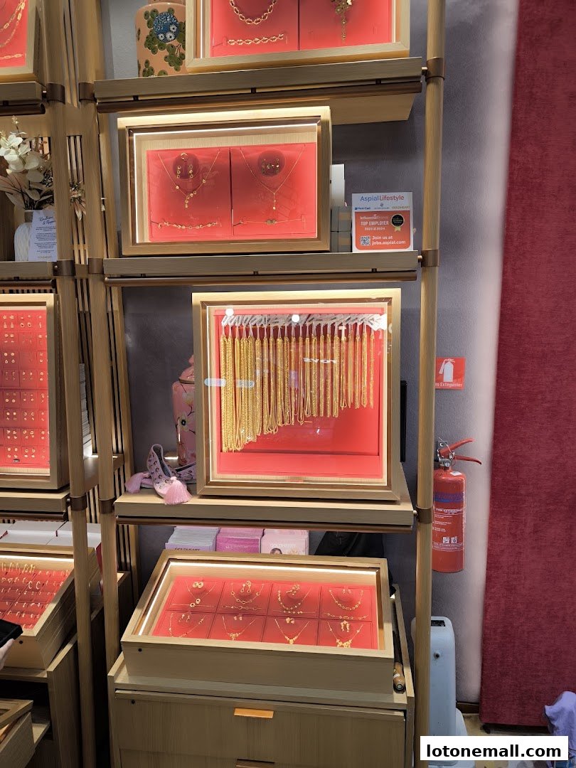 Display shelves showcasing various gold necklaces and jewelry sets in illuminated cases.