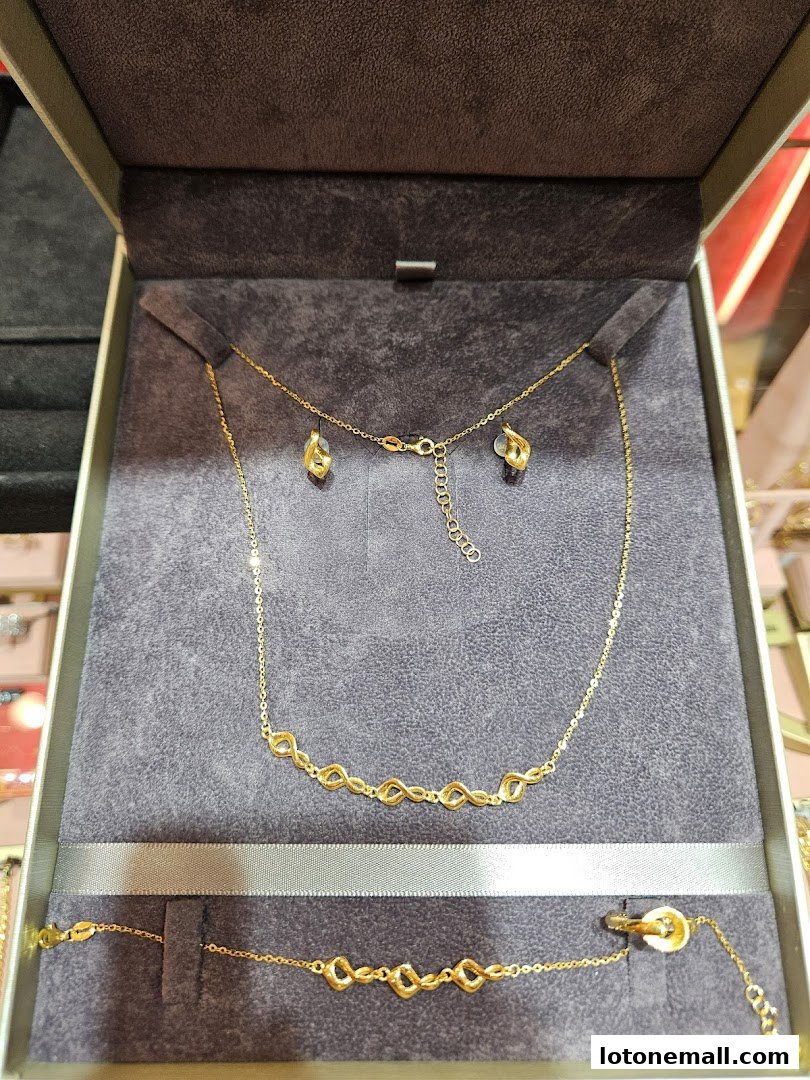 A jewelry set featuring a gold necklace, earrings, and bracelet with infinity designs.