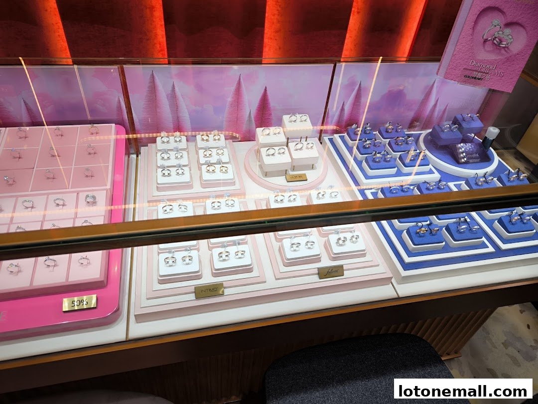 A jewelry display case filled with rings and earrings, featuring pink and blue velvet stands.
